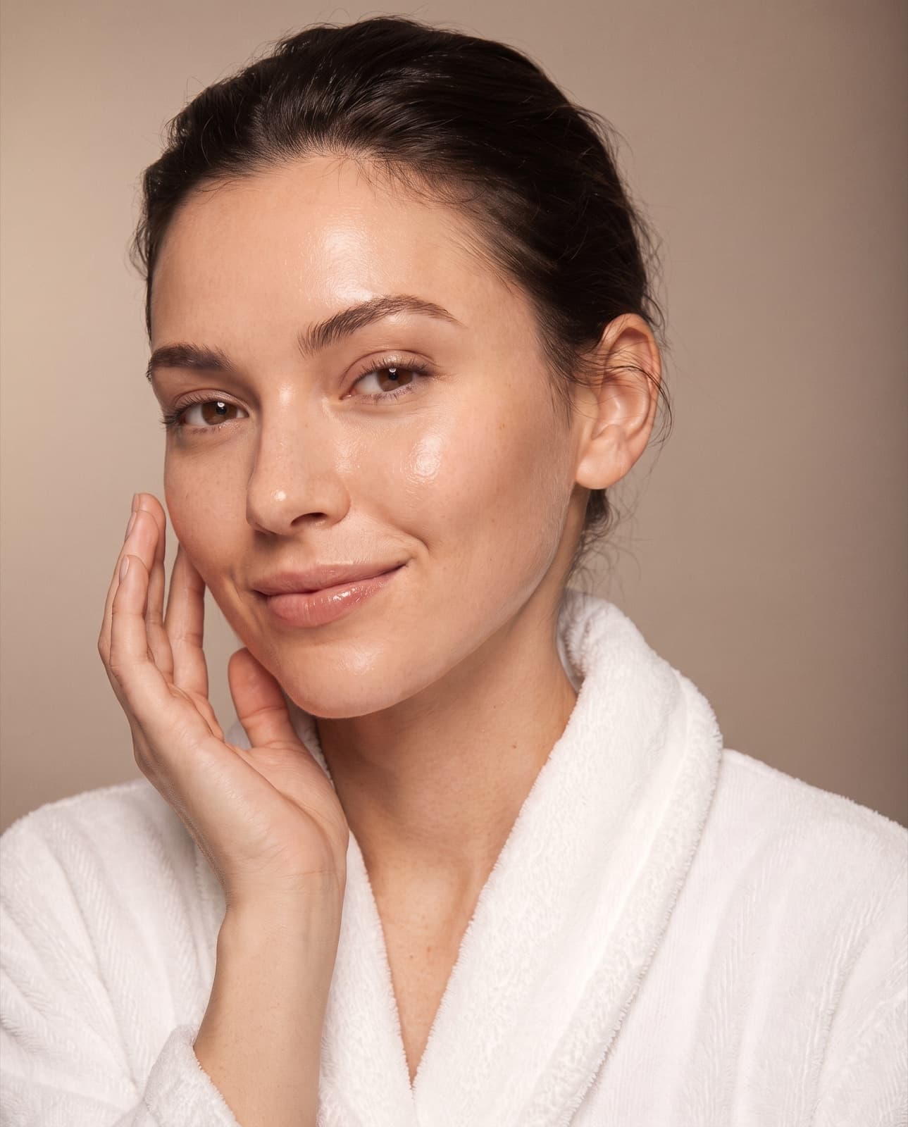 A woman touching her face in soft natural light